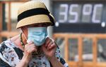 A woman passes a temperature display during a heatwave in central Moscow on June 23.