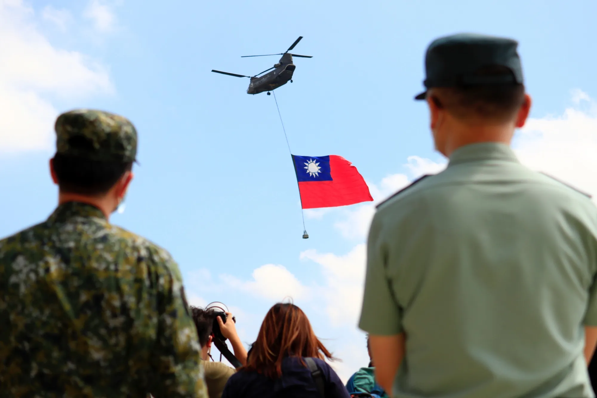 A military helicopter carrying a Taiwanese flag flies during a rehearsal for the Double Tenth Day celebration in Taoyuan on Sept. 28.