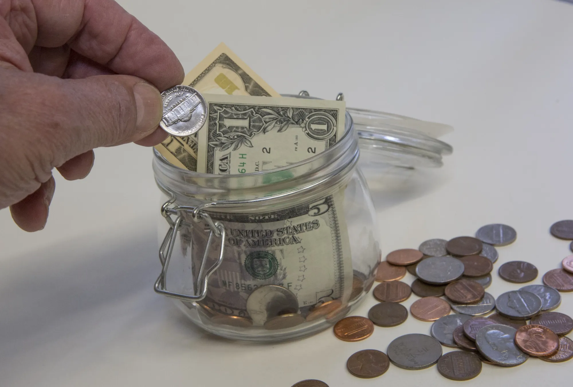 Symbol photo on the topics saving up. Dollar banknotes and coins.