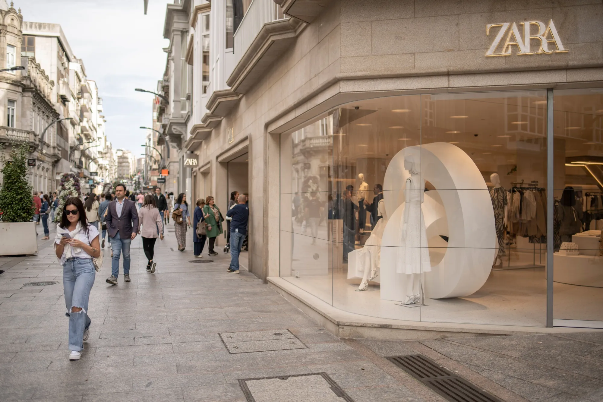 Shoppers pass a Zara clothing store&nbsp;in Vigo, Spain.