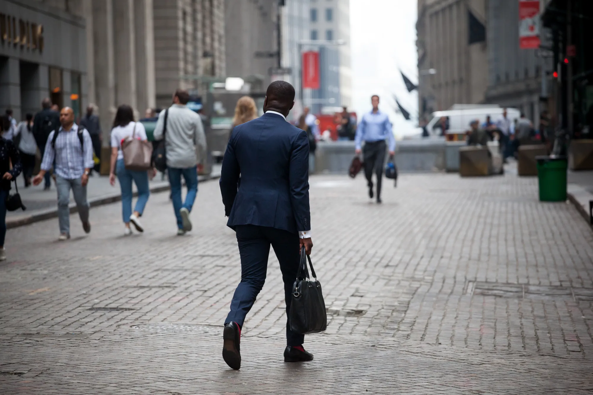 Pedestrians walk along Wall Street near the New York Stock Exchange.