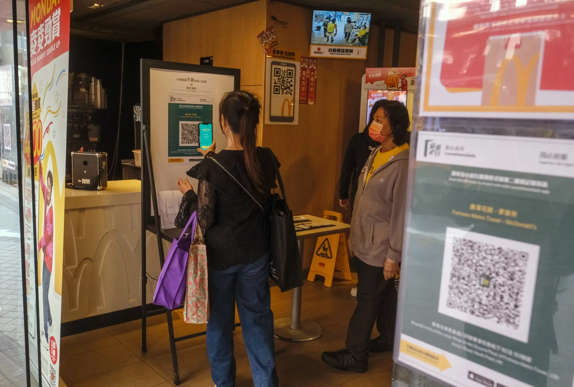 A customer scans a QR code for the LeaveHomeSafe Covid-19 contact-tracing app prior entering a McDonald restaurant in Hong Kong.