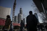 Pedestrians walk past a construction crane in downtown Beijing.