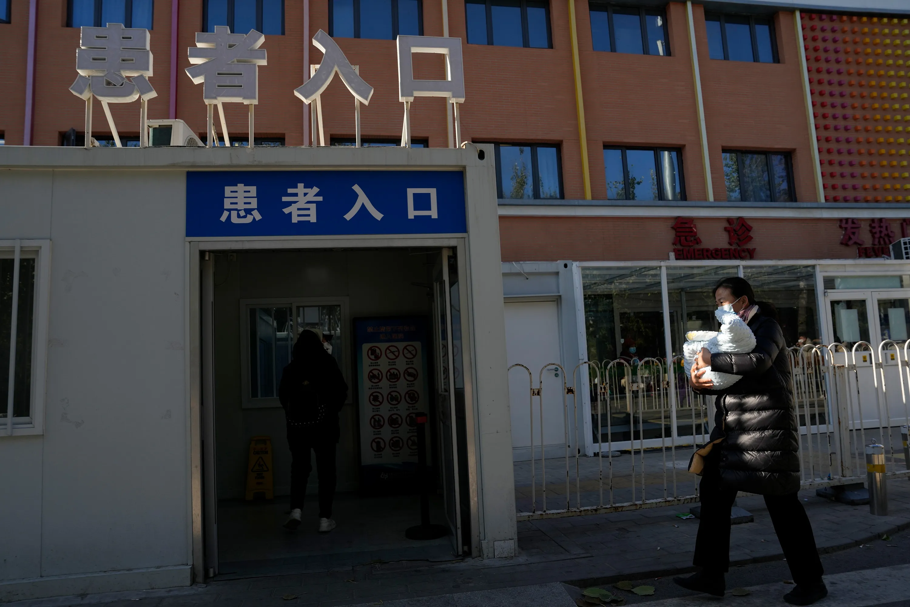 A visitor carries a child into a children's hospital&nbsp;in Beijing, China.