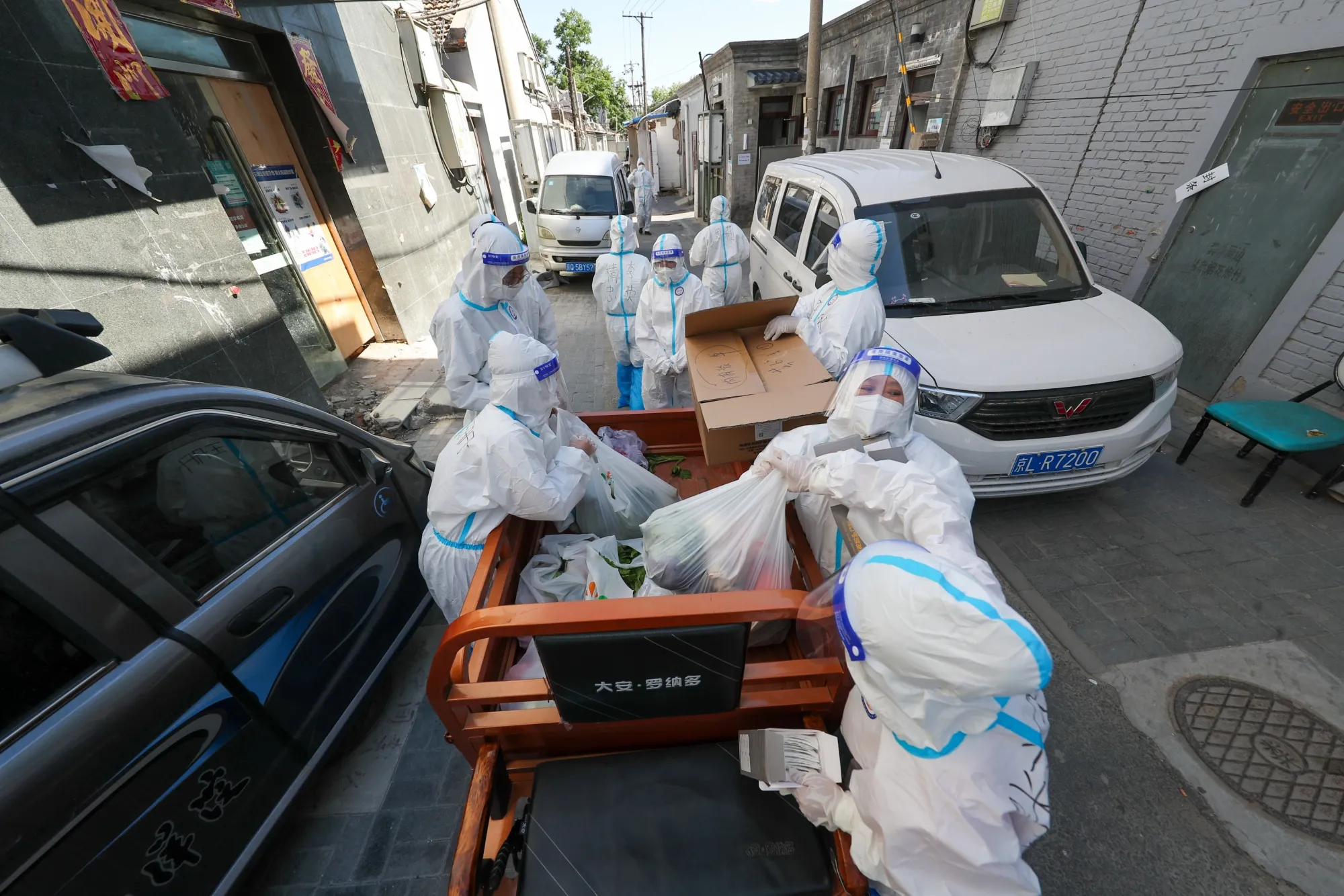 Volunteers deliver food supplies to residents at a residential community under restrictions in Beijing on June 5.