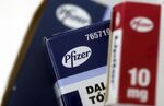 The Pfizer Inc. logo sits on boxes of tablets on a pharmacy counter in this arranged photograph in London, U.K., on Thursday, Dec. 29, 2016.