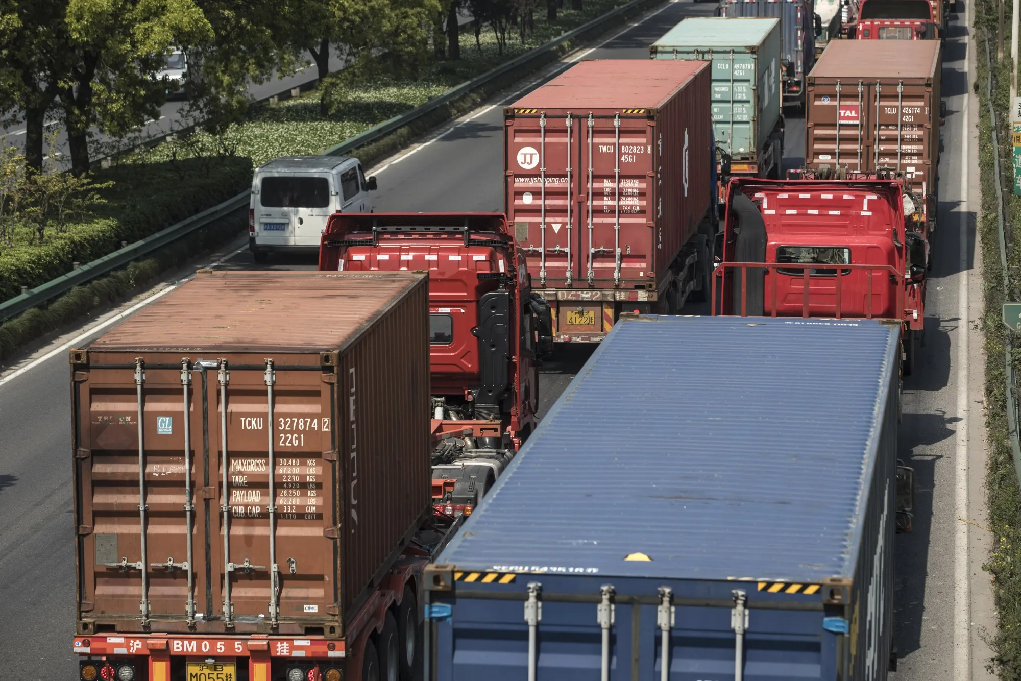 Trucks and semi-trailers wait in line on a highway leading into the city in Shanghai, April 24.