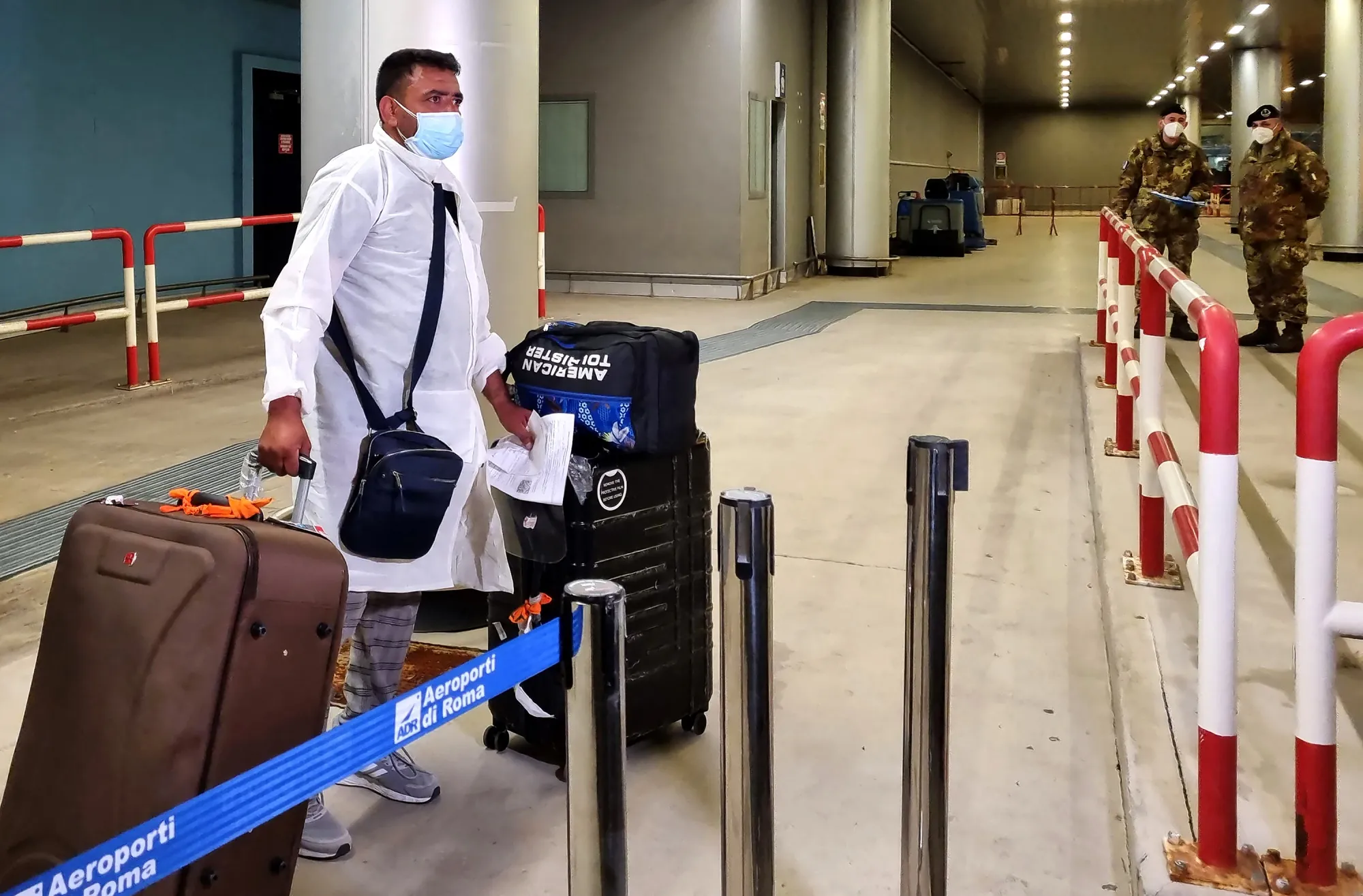 A passenger flying in from India arrives with their luggage at Fiumicino International airport in Italy.