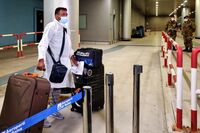 A passenger flying in from India arrives with their luggage at Fiumicino International airport in Italy.