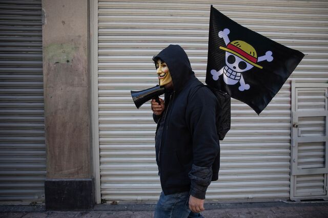 Демонстрант идет с флагом пирата во время акции протеста в Мехико. 