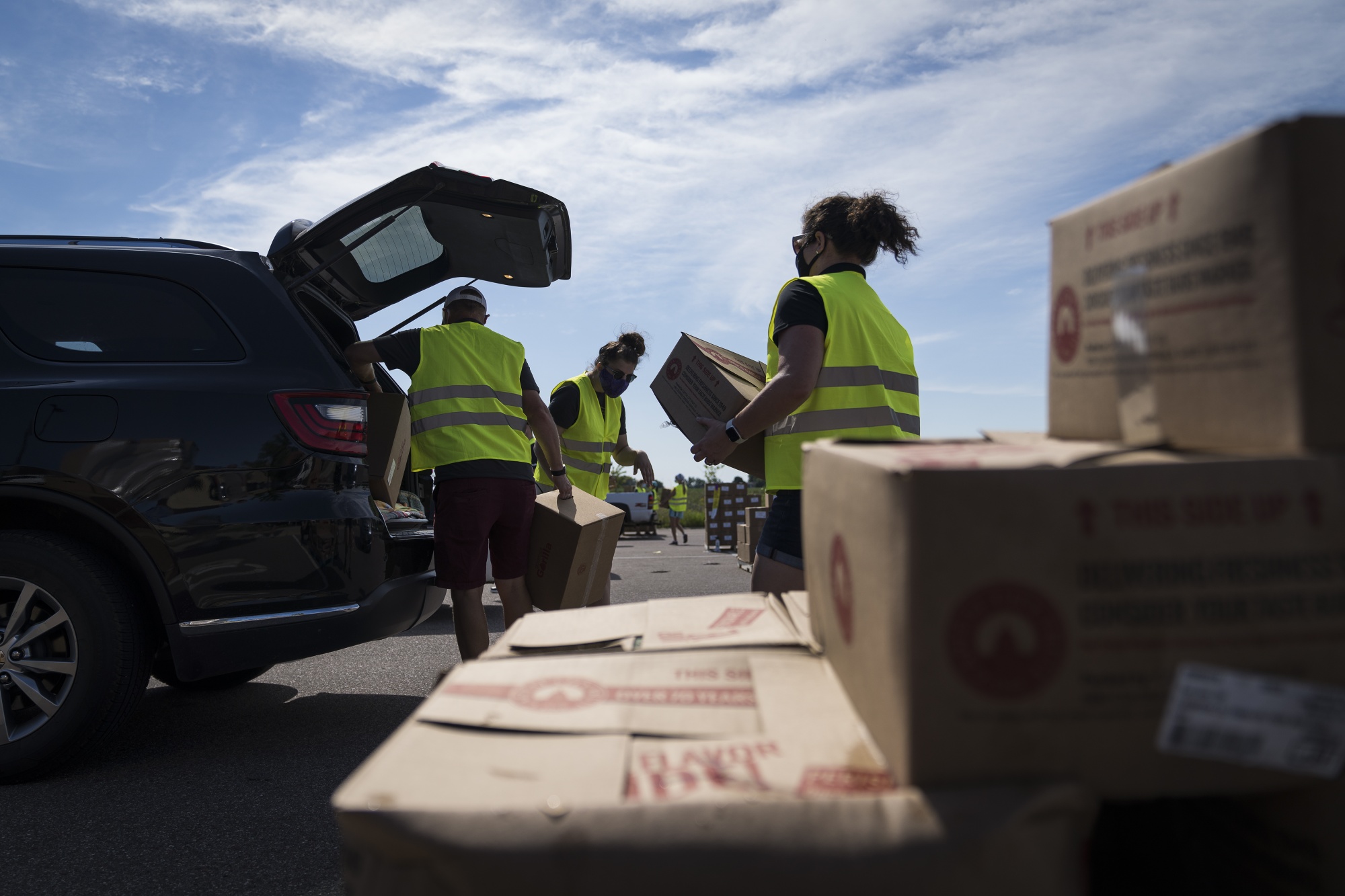 Volunteers unload and distribute food items at a pop-up grocery event at Prairie Winds Middle School in Mankato, Minnesota on July 23, 2020. 