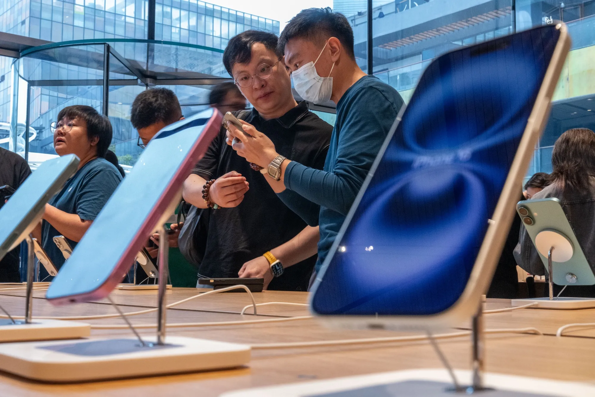 A shop assistant serves a customer inside the Apple Inc. Sanlitun store in Beijing, China.