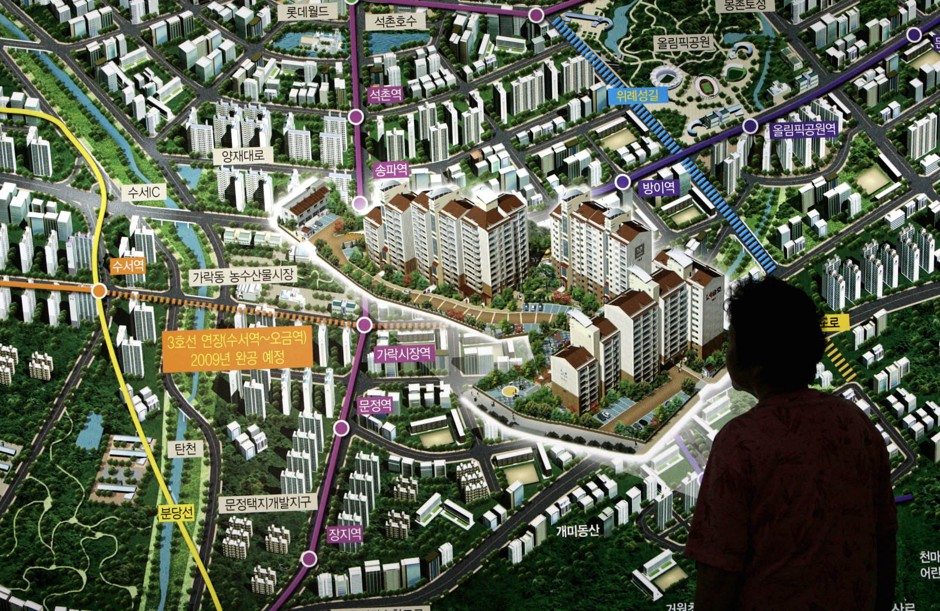 A prospective buyer looks at a rendering of a new apartment complex in Seoul in 2005.