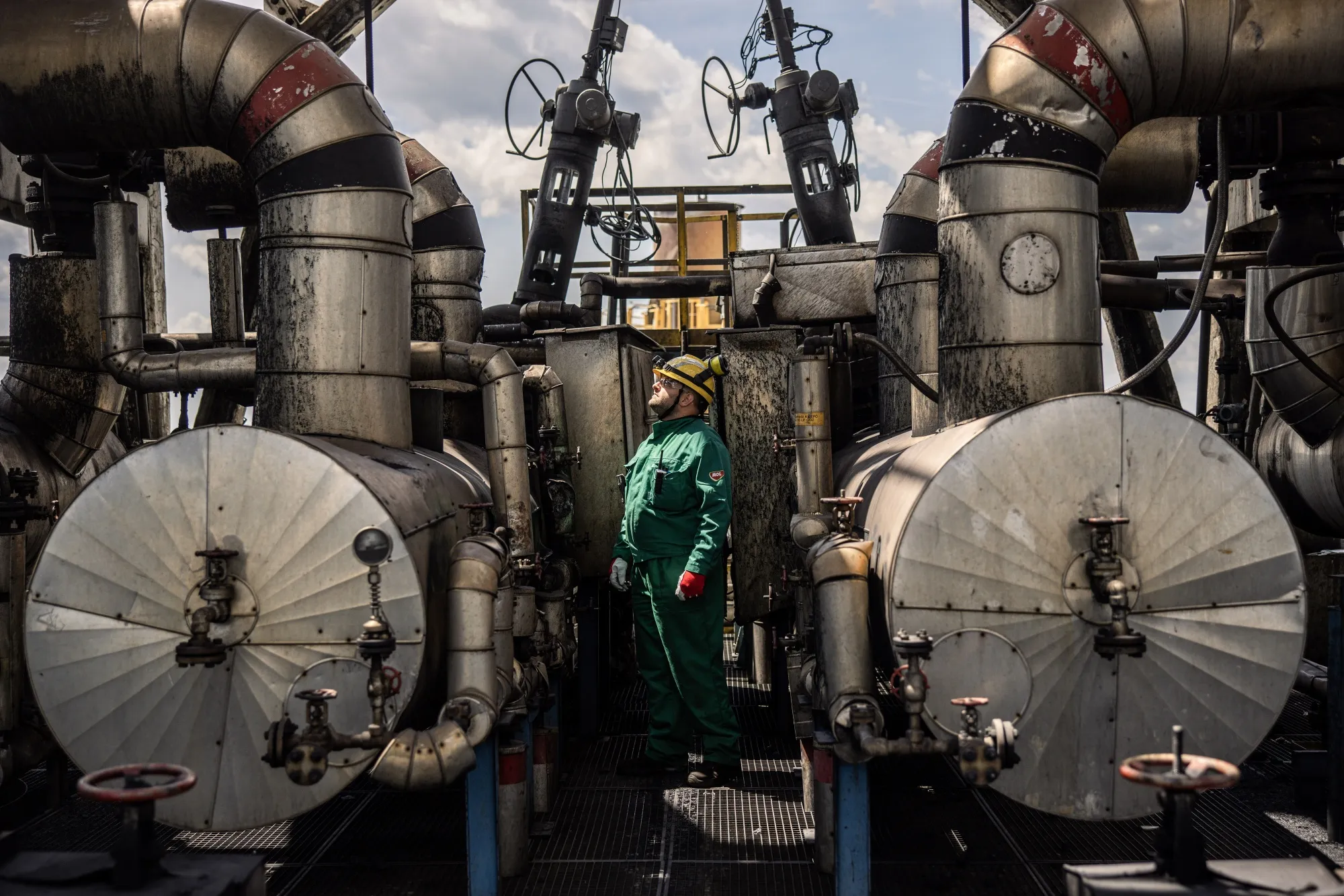 A worker inspects refining structures at an oil refinery in Szazhalombatta, Hungary.