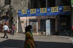 Pedestrians pass a Life Insurance Corp. of India branch office in Mumbai, India.