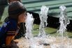 A girl plays at a water fountain in Sing