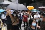 Demonstrators raise their hands to gesture the "Five demands, not one less" protest motto in the Central district during a protest in Hong Kong, China, on Wednesday, May 27, 2020.