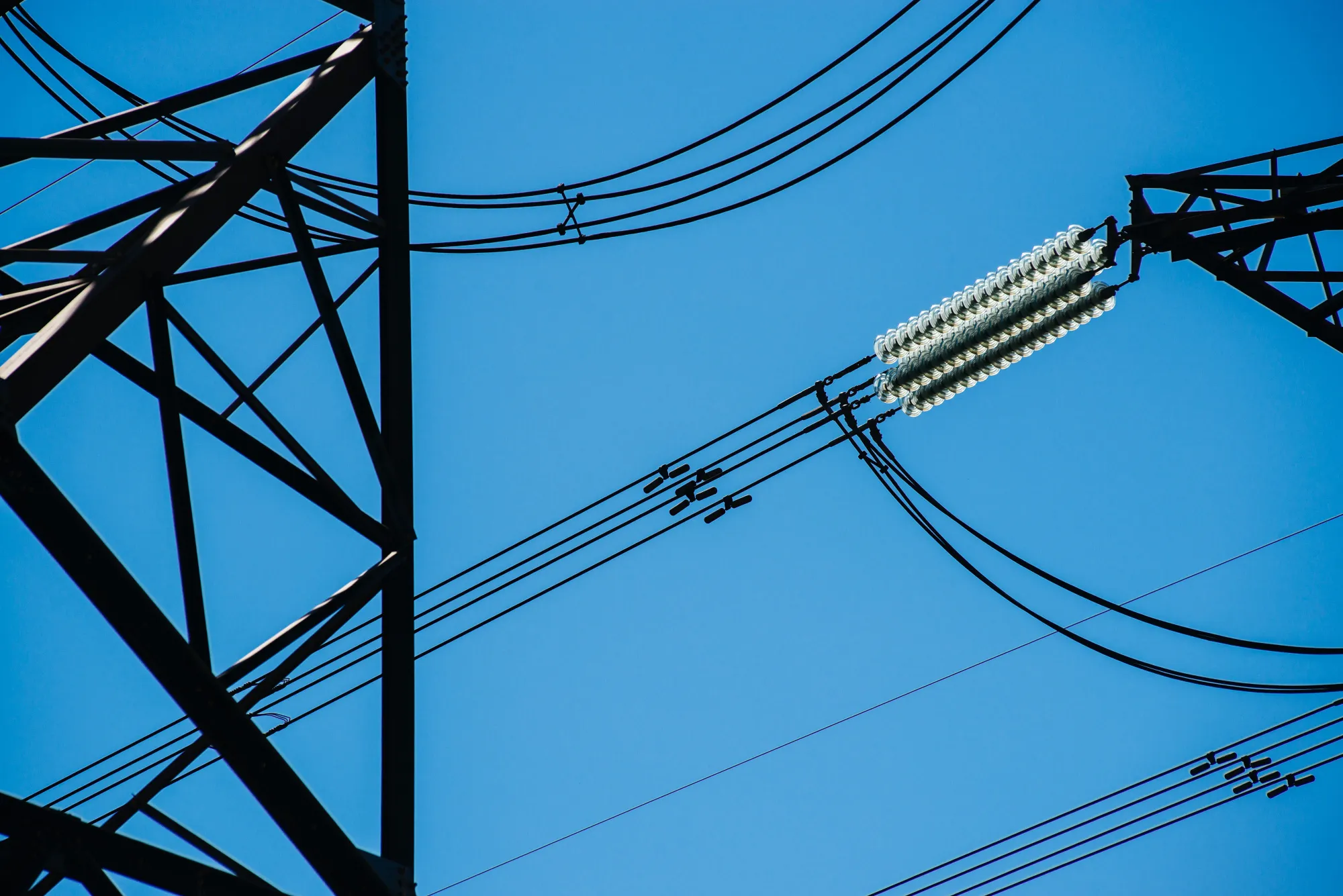 Pylon towers carry electrical power lines across land in Johannesburg, South Africa, on Thursday, Oct. 6, 2016. Eskom Holdings SOC Ltd. is building new electricity stations to end the power cuts that were imposed for about 100 days last year, curbing growth in Africa's most-industrialized nation.