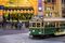An iconic W-class Melbourne tram (no 946) crosses flinders street at night in front of Flinders Street Station after work