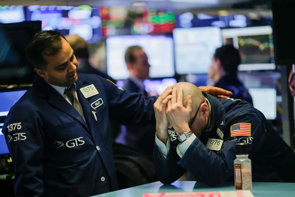 A trader is comforted by a coworker as they work on the floor of the New York Stock Exchange (NYSE) on March 1, 2018 in New York City. Major stock indexes plunged Thursday afternoon following President Trump's announcement that he was imposing a 25 percent tariff on imported steel and 10 percent on aluminum. Investor concern about the news rattled the Dow Jones industrial average, which closed down more than 400 points.
