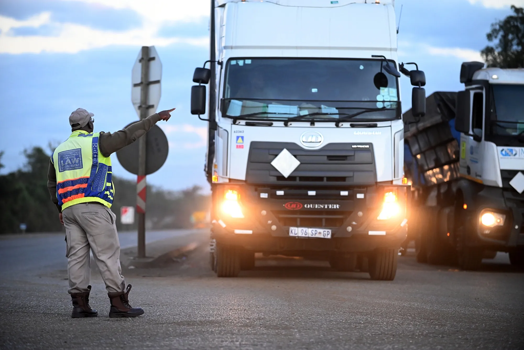 A traffic officer directs a truck driver, waiting to cross South Africa’s border into Mozambique, at Lebombo Border control in Komatipoort, South Africa, on Friday, July 14, 2023.