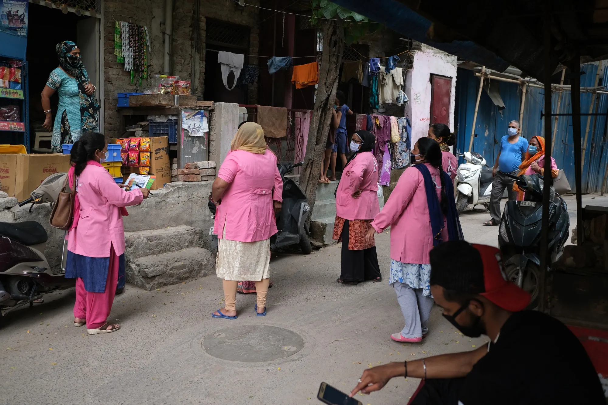 Asha workers speak to a resident, left, as they conduct a door-to-door survey on the coronavirus in New Delhi in July 2020.