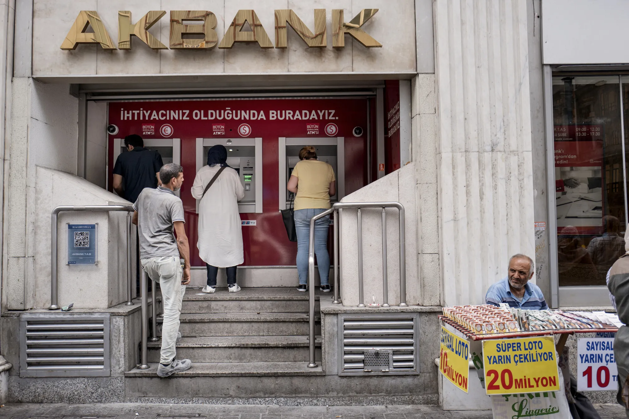 Customers use automated teller machines operated by Akbank TAS in Istanbul, Turkey.
