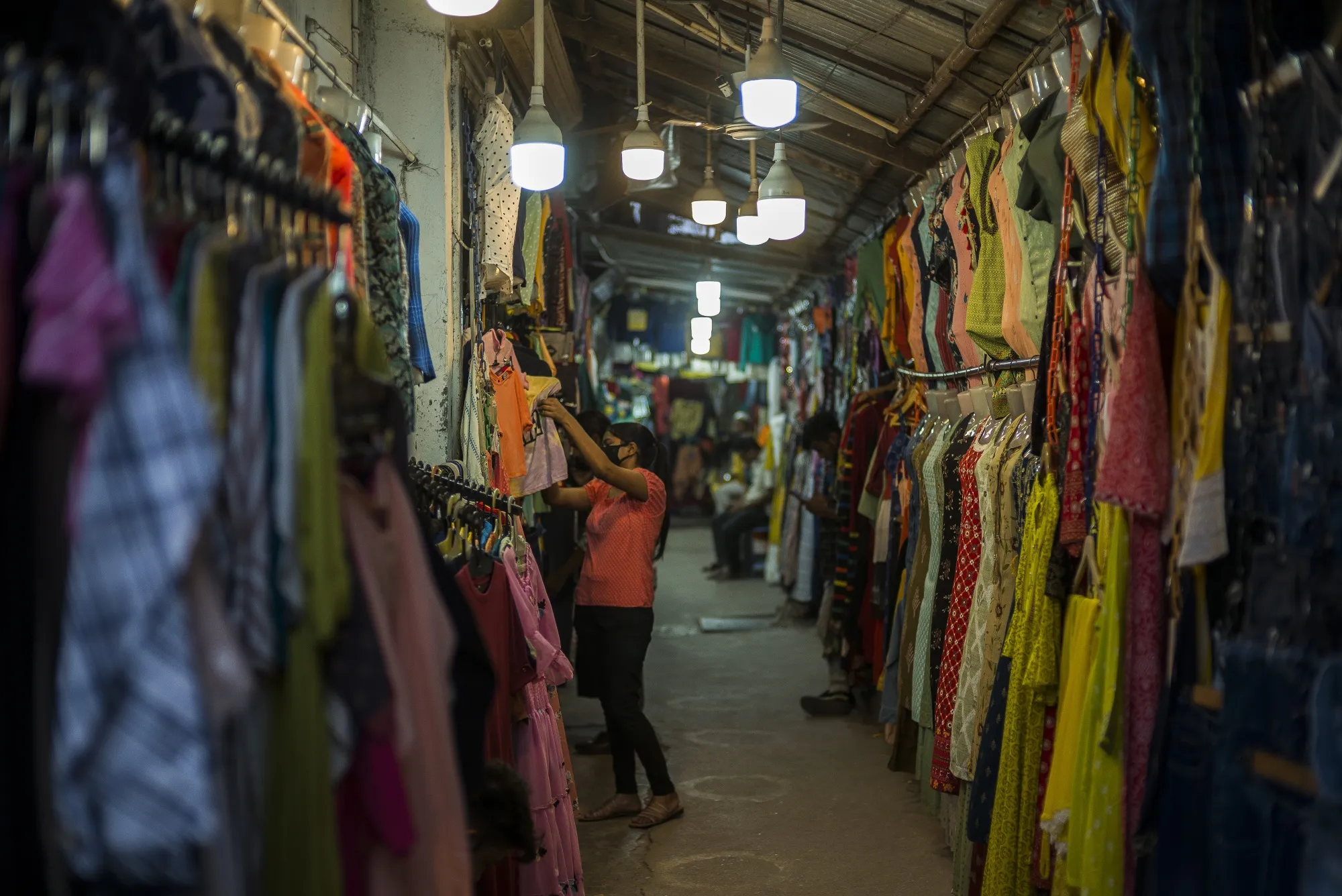 A shopper browses clothes in a market in Lucknow, India.