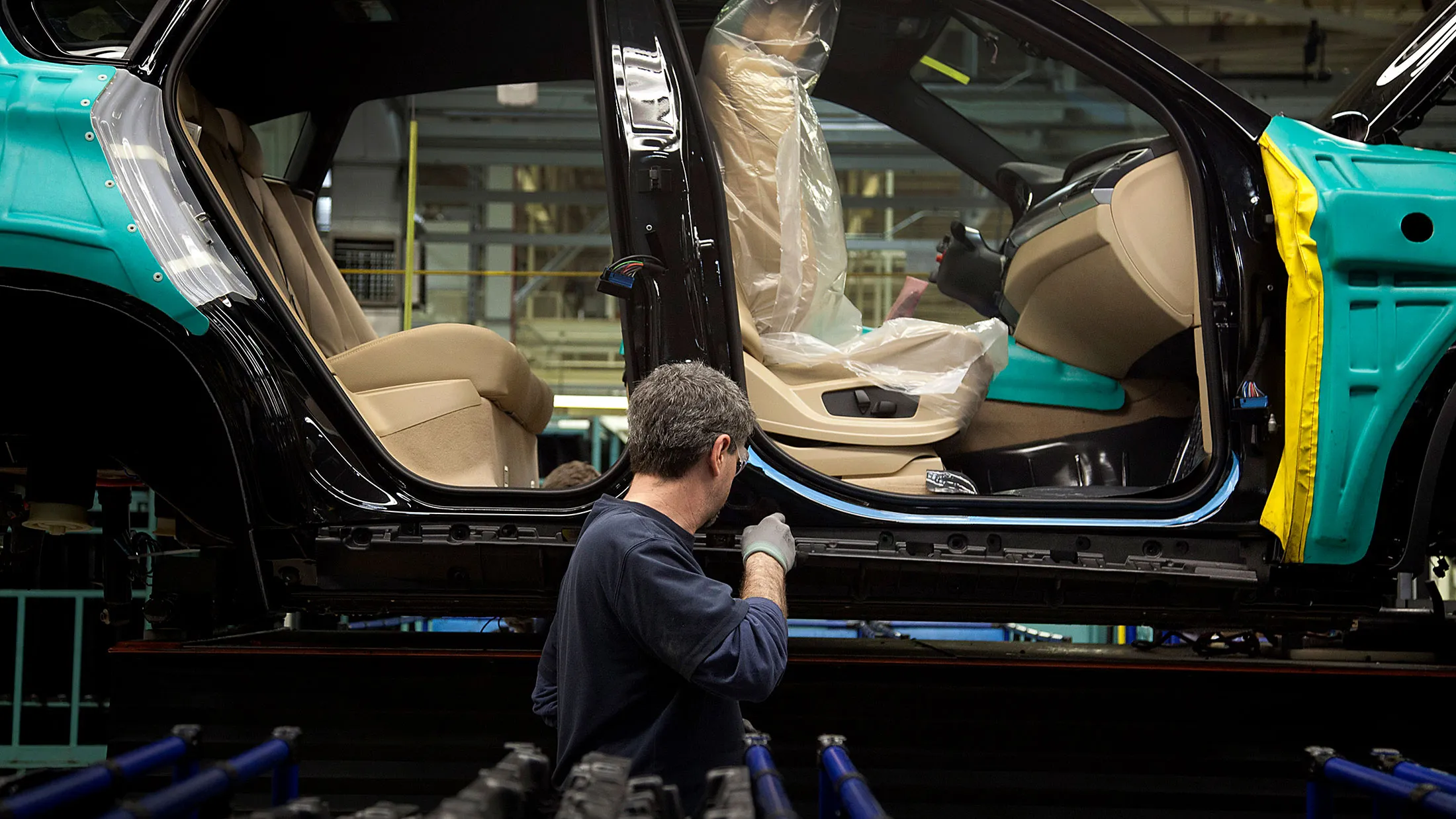 A worker inspects a vehicle on the production line at the BMW manufacturing plant in Spartanburg, South Carolina, on Jan. 11, 2012.
