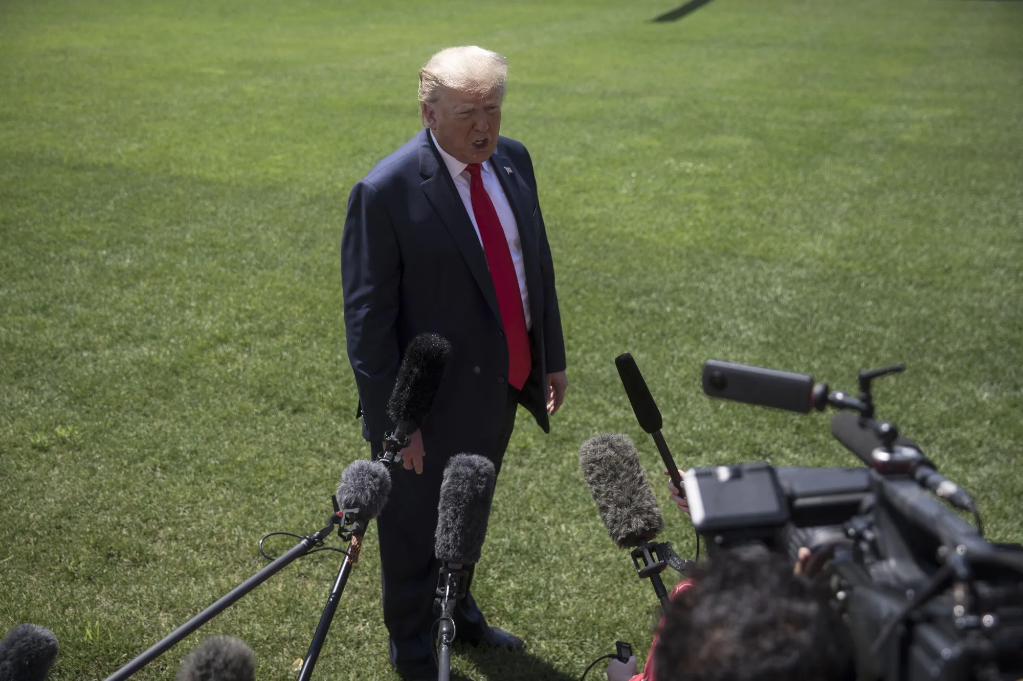 U.S. President Donald Trump speaks to members of the media before boarding Marine One on the South Lawn of the White House.