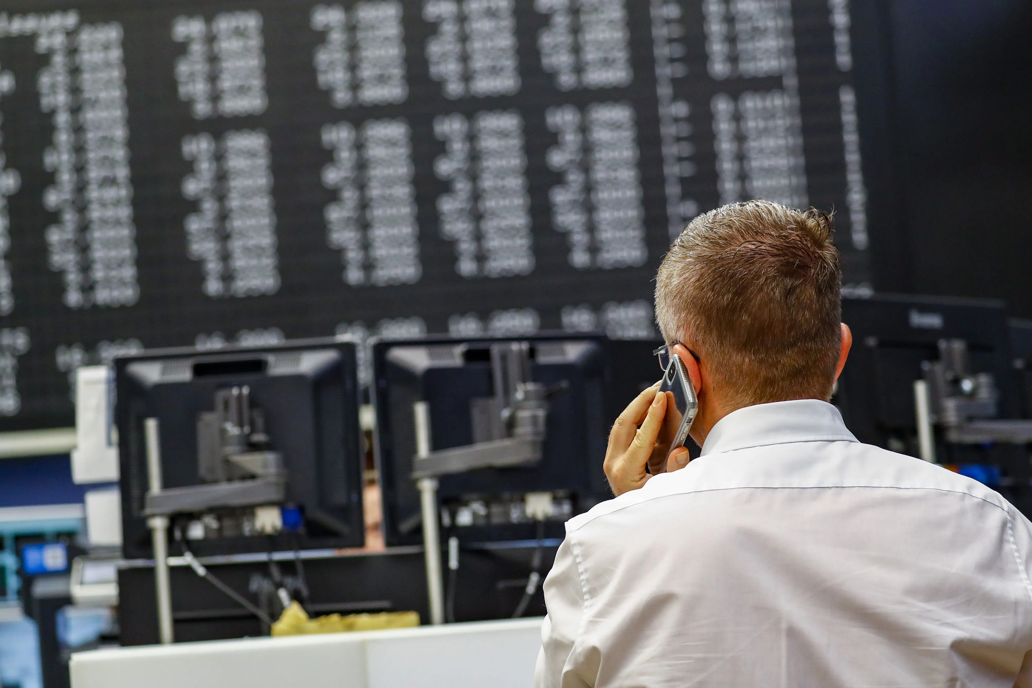 A trader speaks on a mobile phone inside the Frankfurt Stock Exchange.