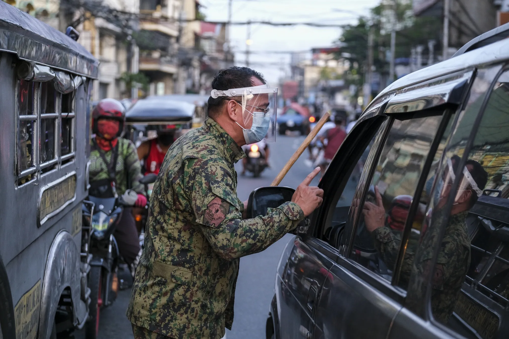 A Philippine National Police checks papers of motorists during lockdown restrictions&nbsp;in Mandaluyong City, Metro Manila.