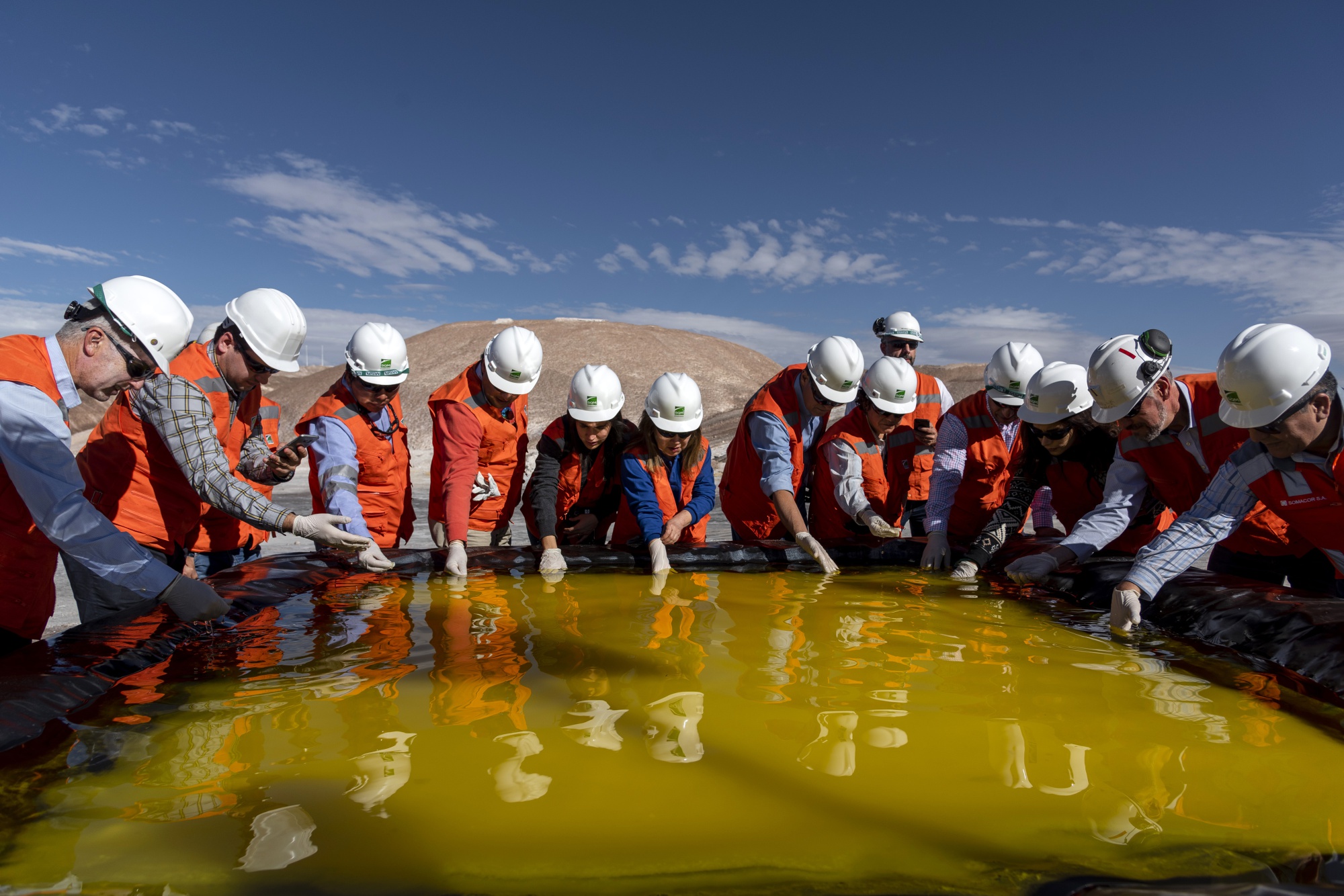 Visitors inspect a brine pool at a Sociedad Química y Minera de Chile (SQM) lithium mine on the Atacama salt flat in the Atacama Desert, Chile on&nbsp;May 29, 2019.
