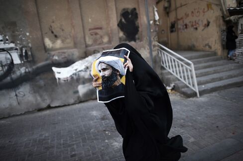 A Bahraini woman holds a poster bearing a portrait of prominent Shiite Muslim cleric Nimr al-Nimr during a protest against his execution by Saudi authorities.
