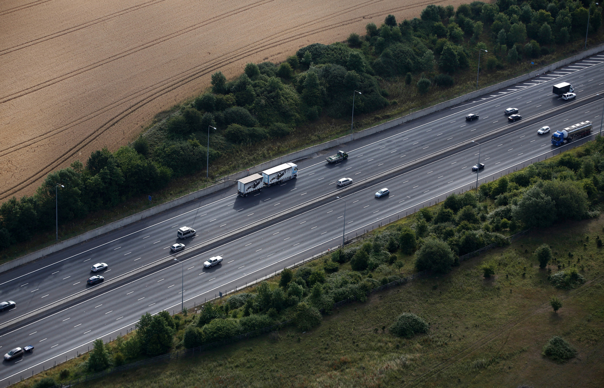 Traffic travels along the M25 motorway in this aerial photograph taken near Upminster, U.K., on Wednesday, July 22, 2015. Passenger journeys on the U.K. rail network rose more than 4 percent to a record 1.65 billion in the fiscal year through March as the country's crowded roads encouraged people to continue an exodus from cars to trains.
