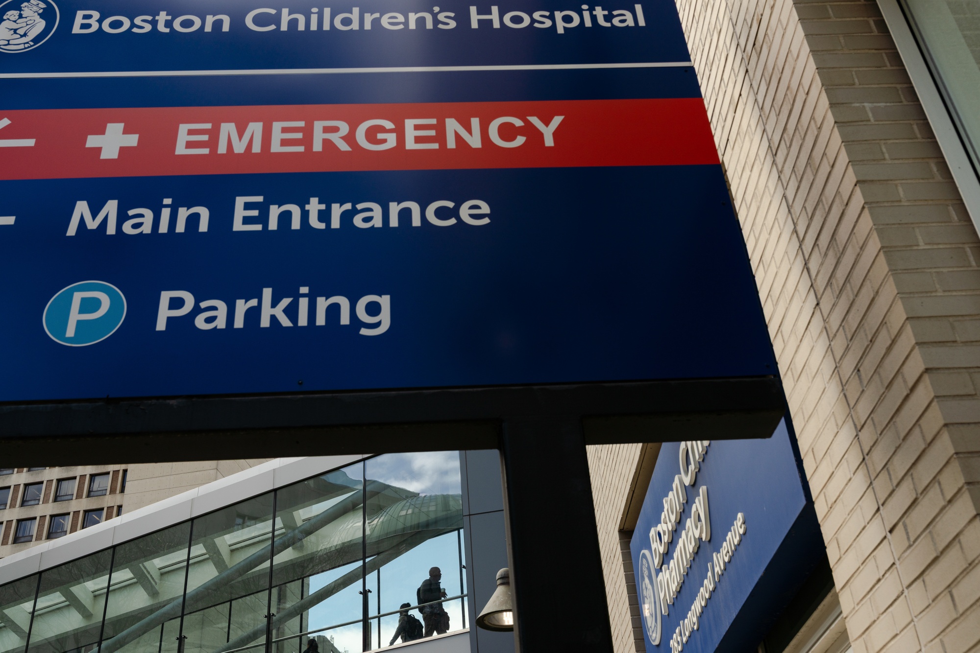 Pedestrians cross a skybridge at Boston Children's Hospital building in Boston, Massachusetts, US, on Wednesday, April 16, 2025. The federal money that flows through Harvard University is linked to major health-care systems, including Mass General Brigham and Boston's Children's Hospital, and a network of researchers, scientists and doctors.
