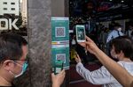 Visitors scan a QR code for the LeaveHomeSafe Covid-19 contact-tracing app in Hong Kong.