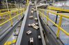 Packages ready for shipment move down a conveyor belt at the Amazon.com Inc. fulfillment center in Baltimore, Maryland, U.S., on Tuesday, April 30, 2019. Amazon.com will spend $800 million in the current quarter to reduce delivery times for top customers to one day from two, trying to revive its main e-commerce franchise and ward off greater competition.
