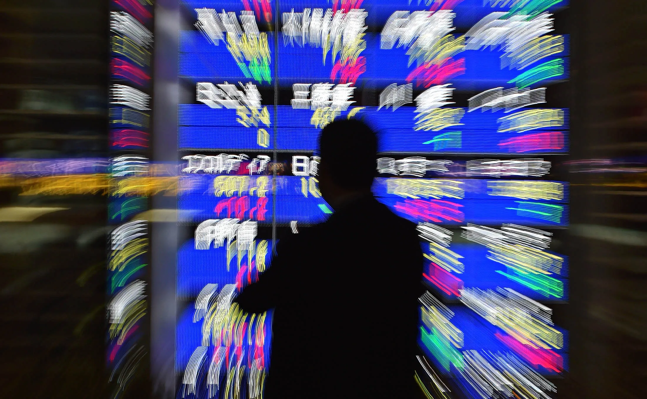 A pedestrian looks at a quotation board flashing the Nikkei key index from the Tokyo Stock Exchange in Tokyo.
