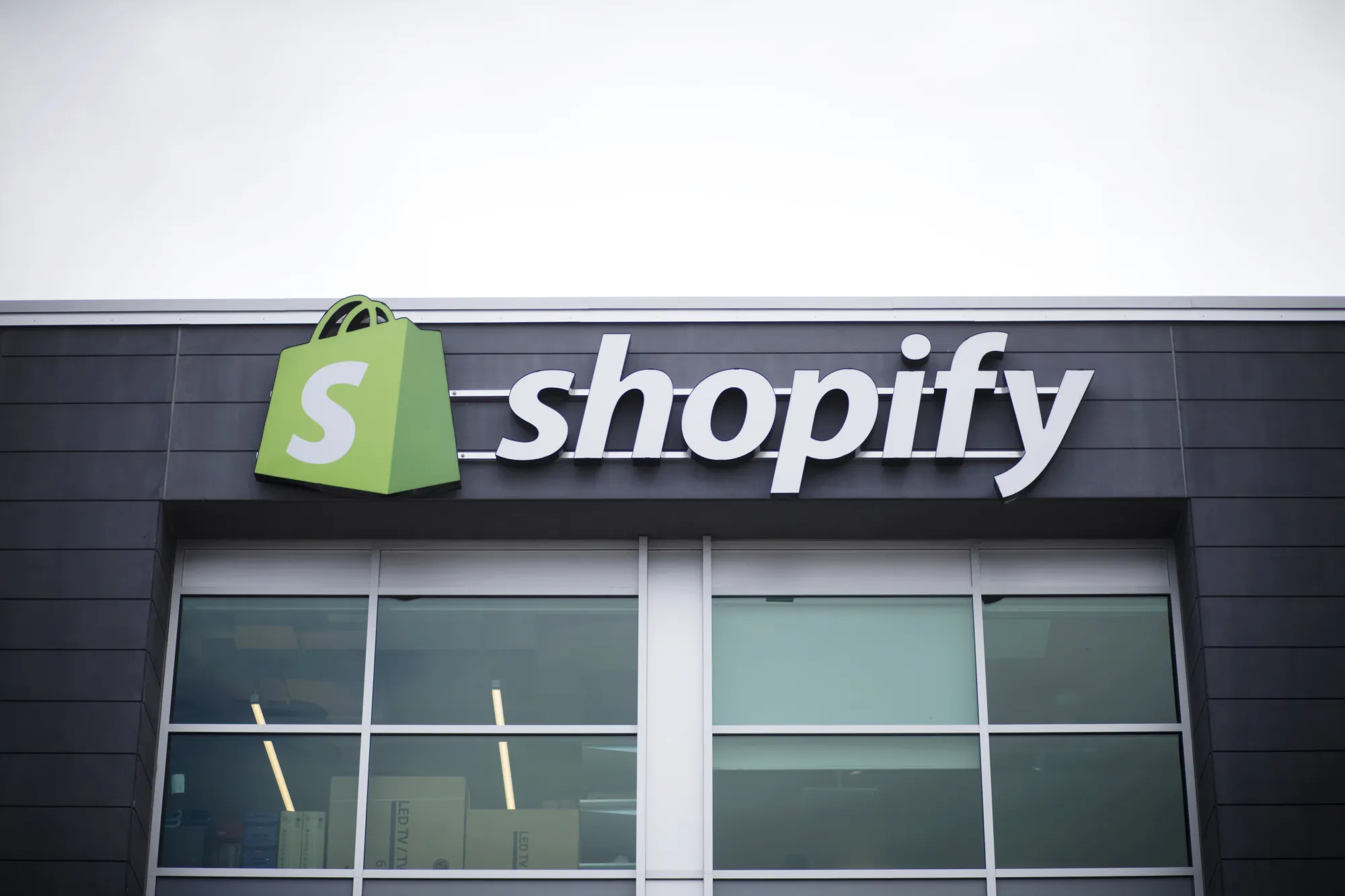 Signage is displayed outside the Shopify Inc. office in Waterloo, Ontario, Canada, on Sept. 13, 2018. Shopify Plus, the company's highest-tiered subscription, is attracting migrations from other platforms. In 2Q, more than 50% of customers that were added to the service were new to the Shopify platform.