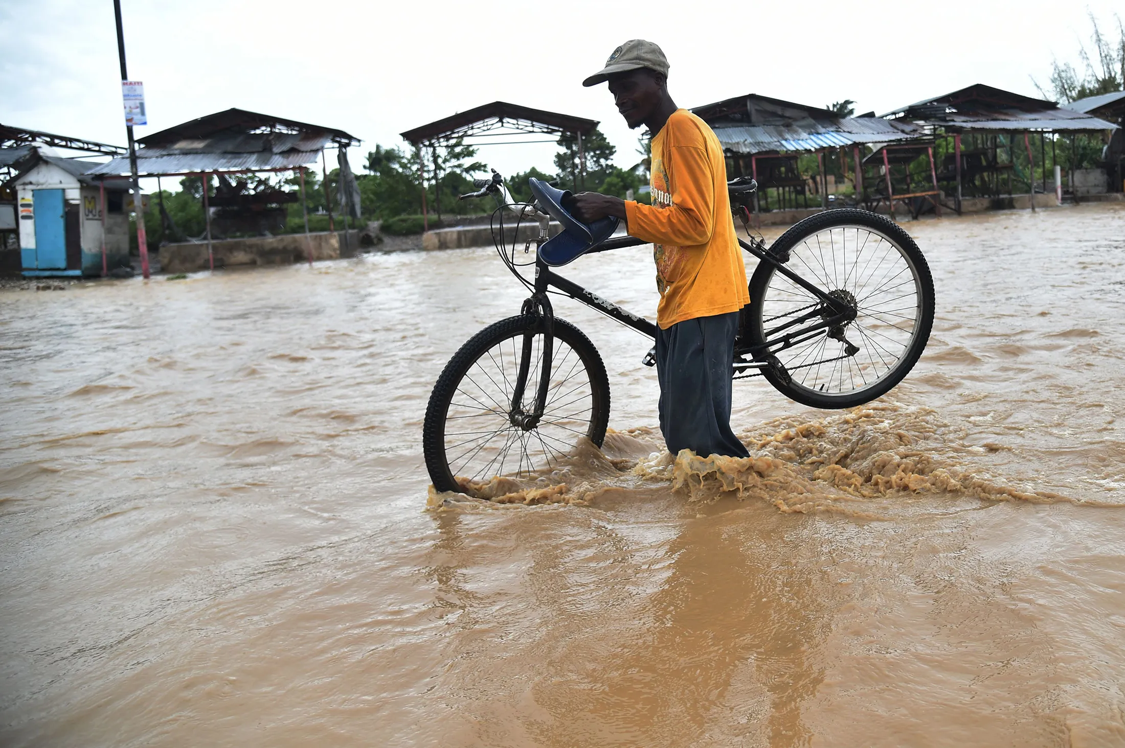A man tries to cross the overflowing Rouyonne river, in the commune of Leogane Port-au-Prince, on Oct. 5, 2016.
