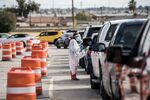 An attendant talks to a person waiting in their car at a coronavirus testing site at Ascarate Park on October 31, 2020, in El Paso, Texas.