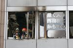 Firefighters stand on a floor at a building where a fire broke out in Osaka, western Japan Friday, Dec. 17, 2021. Japan's NHK says a fire broke out in the building and dozens of people were feared dead. (Kyodo News via AP)