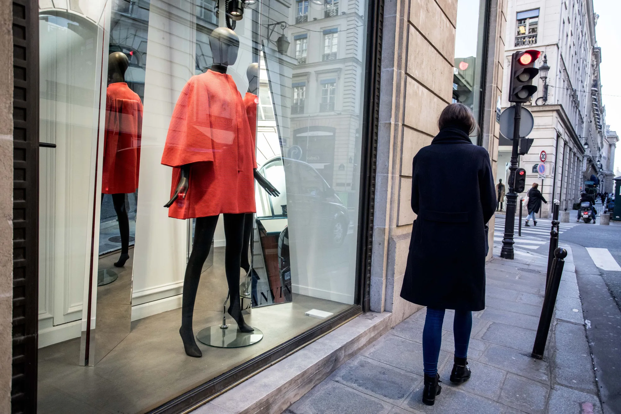 A pedestrian passes a luxury clothing fashion store on Rue du Faubourg Saint-Honore in Paris.