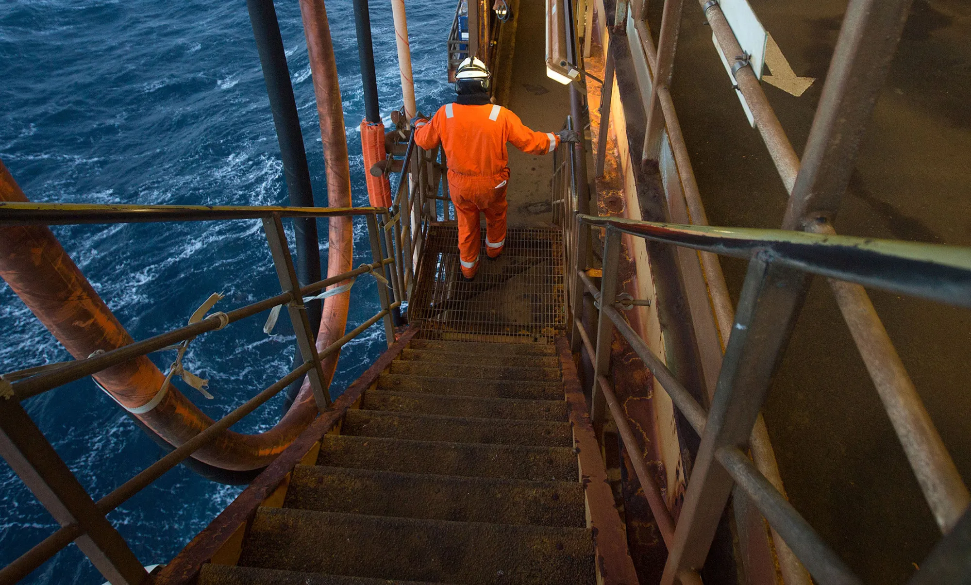 A worker walks down stairs on a gas platform in the North Sea.
