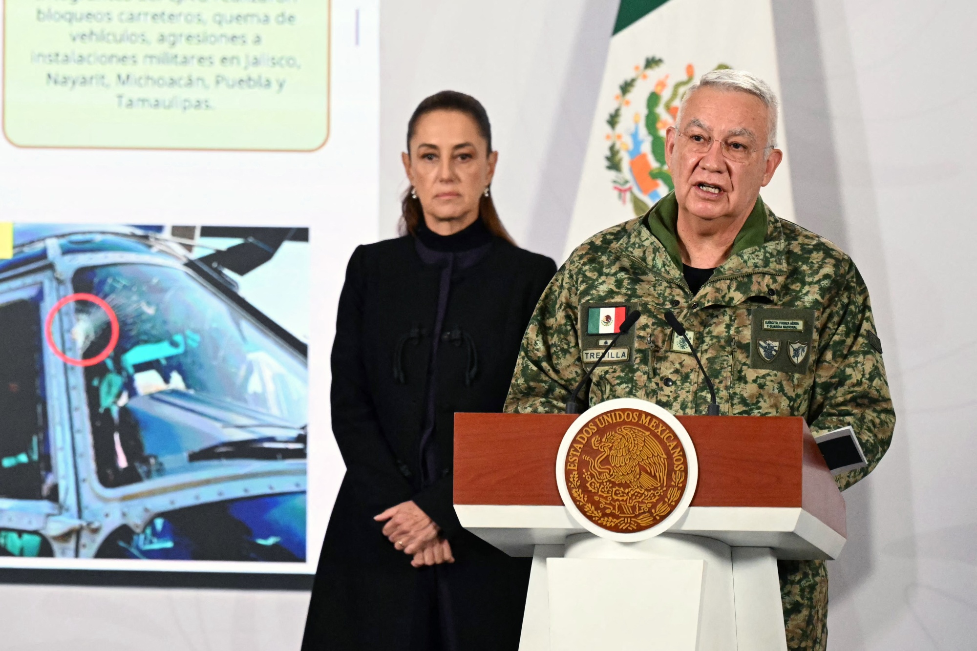 Mexico's Minister of Defence Ricardo Trevilla Trejo speaks next to President Claudia Sheinbaum during her daily press conference at the Palacio Nacional in Mexico City on Feb. 23. Photographer: Yuri Cortez/AFP/Getty Images