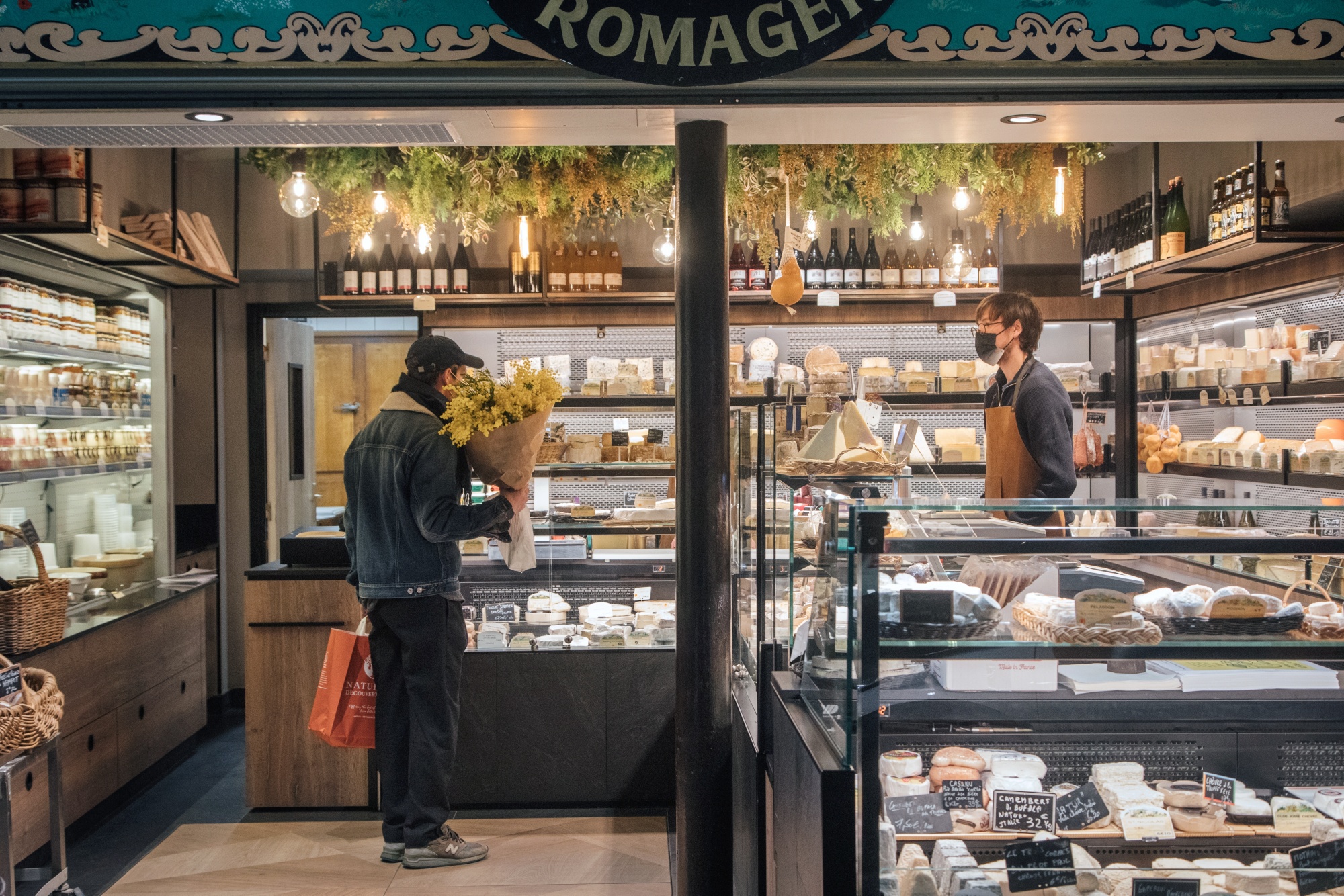 A cheesemonger serves a customer at a deli in Paris. Photographer: Cyril Marcilhacy/Bloomberg