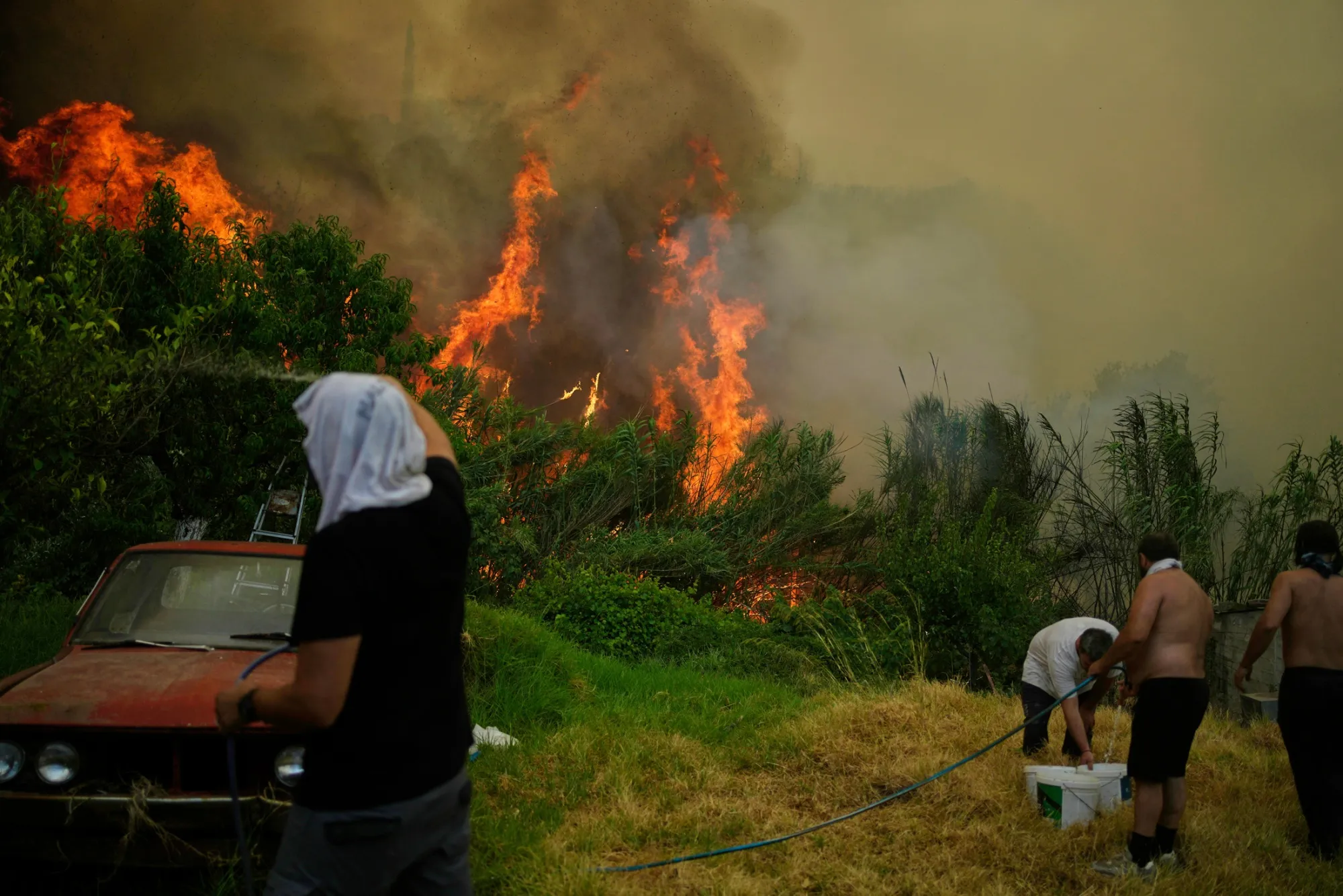 People tackle a wildfire in Vounteni, near Patras, Greece, on Aug. 13.