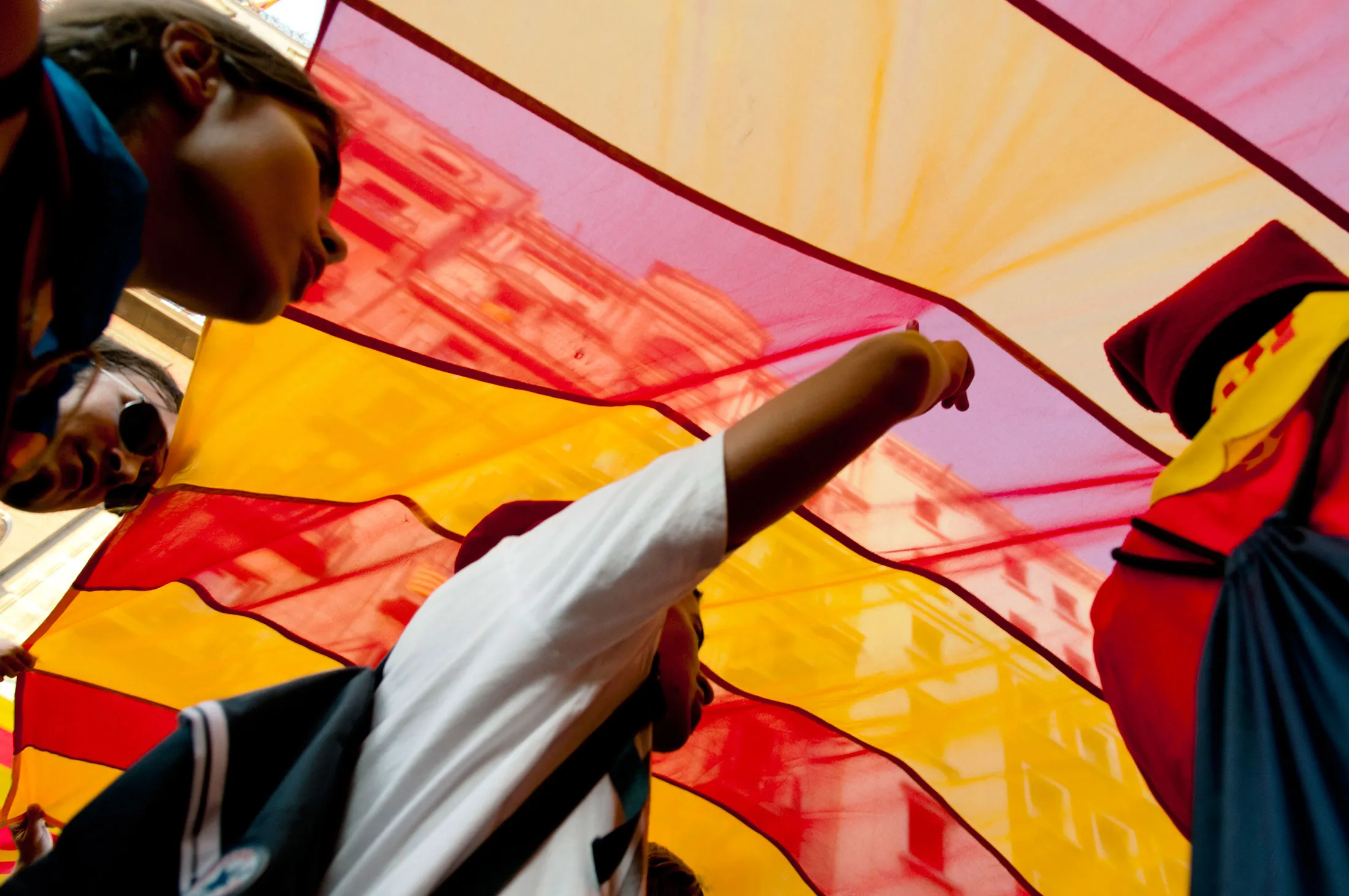 Protestors march beneath a large Catalan flag during a demonstration in favour of regional independence in Barcelona, Spain, on Sept. 11, 2012.
