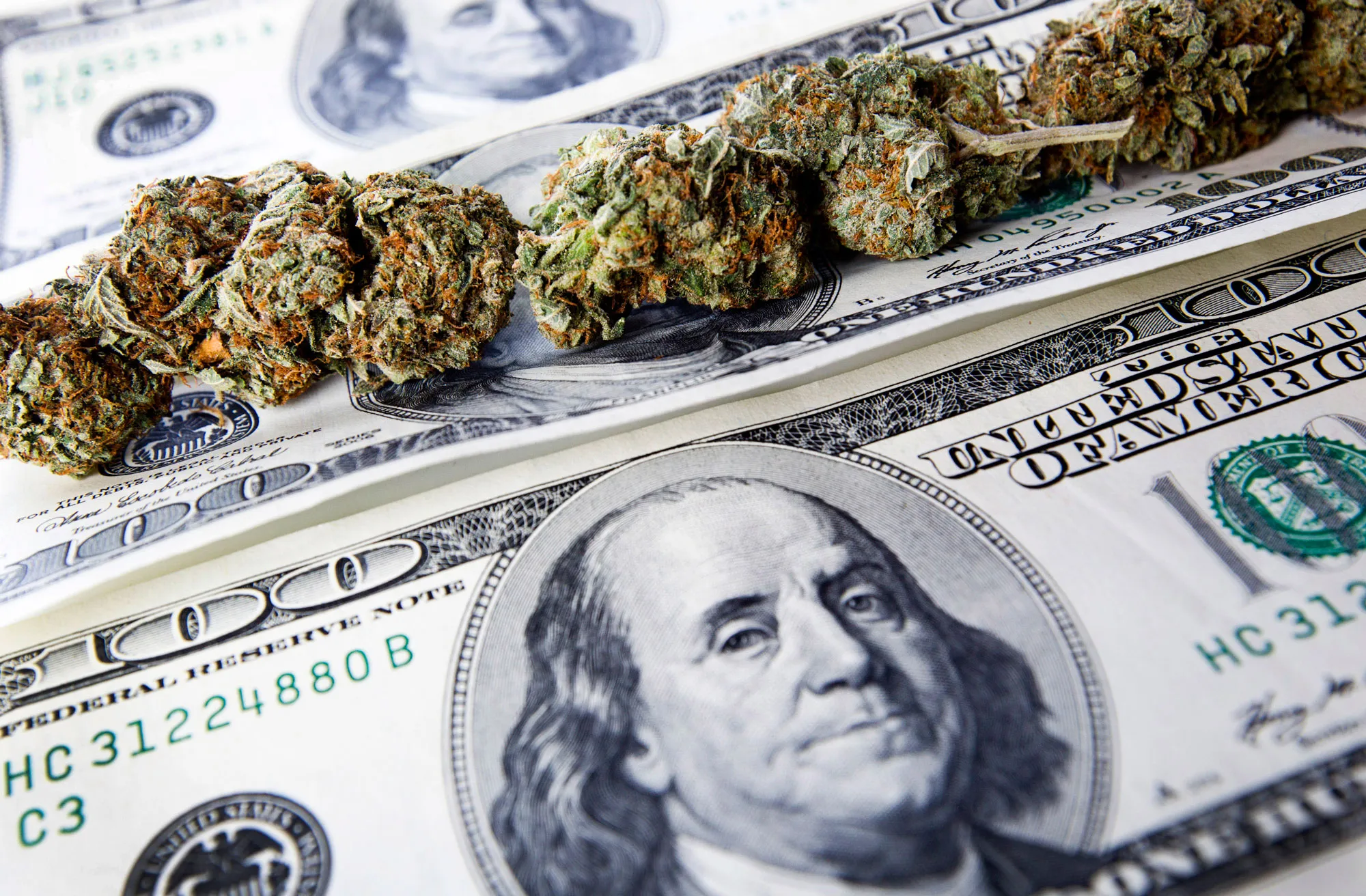 Marijuana buds and one hundred U.S. dollar bills ($100) are arranged for a photograph in Toronto, Ontario, Canada, on Wednesday, Oct. 26, 2011
